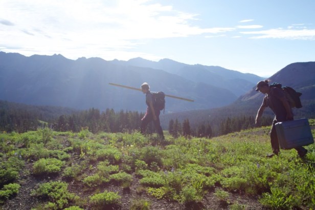 Rozi and Sabastian carrying field equipment to the study’s highest-elevation site.