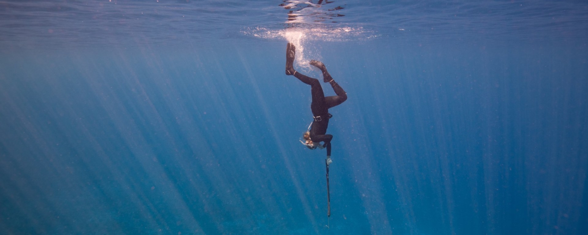 Nina diving to collect fishes in French Polynesia. Copyright: Jennifer Adler