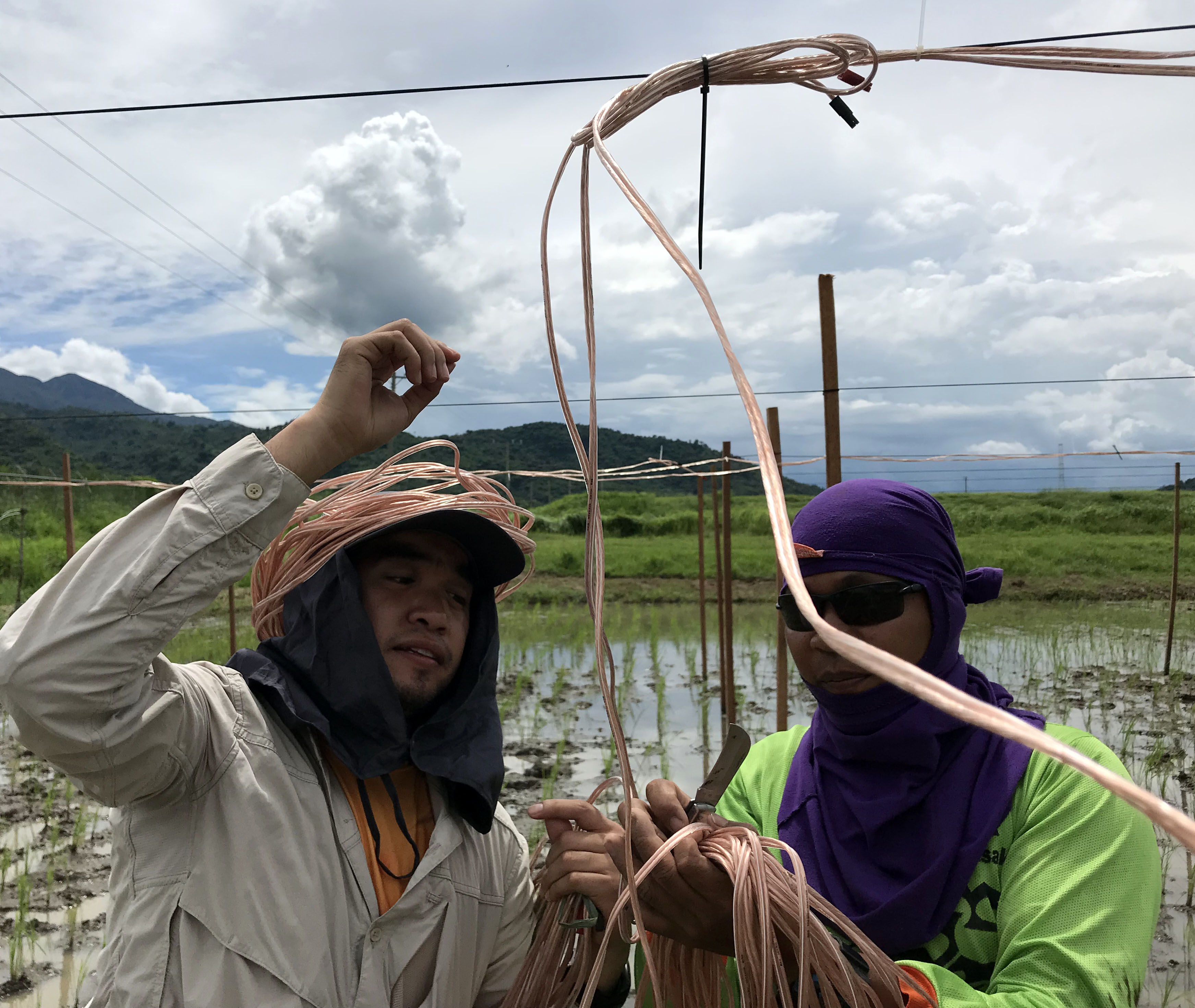 James Alvarez (left) and Jonas Llamas (right) running speaker wire across the speaker array. 